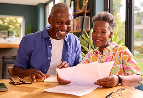 Couple sitting at dining room table reviewing bills.