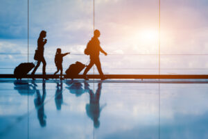 Family at airport travelling with young child and luggage walkin